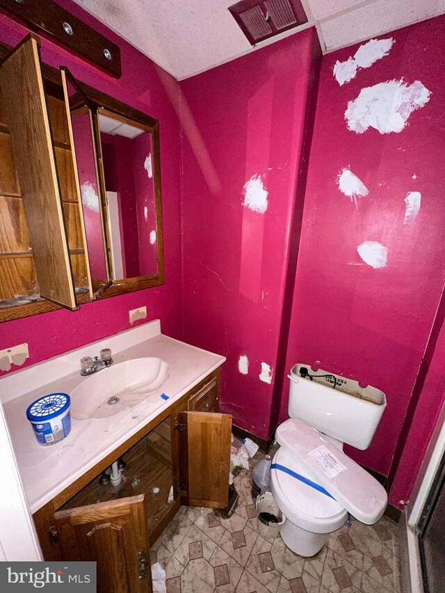 bathroom with toilet, vanity, and tile patterned floors