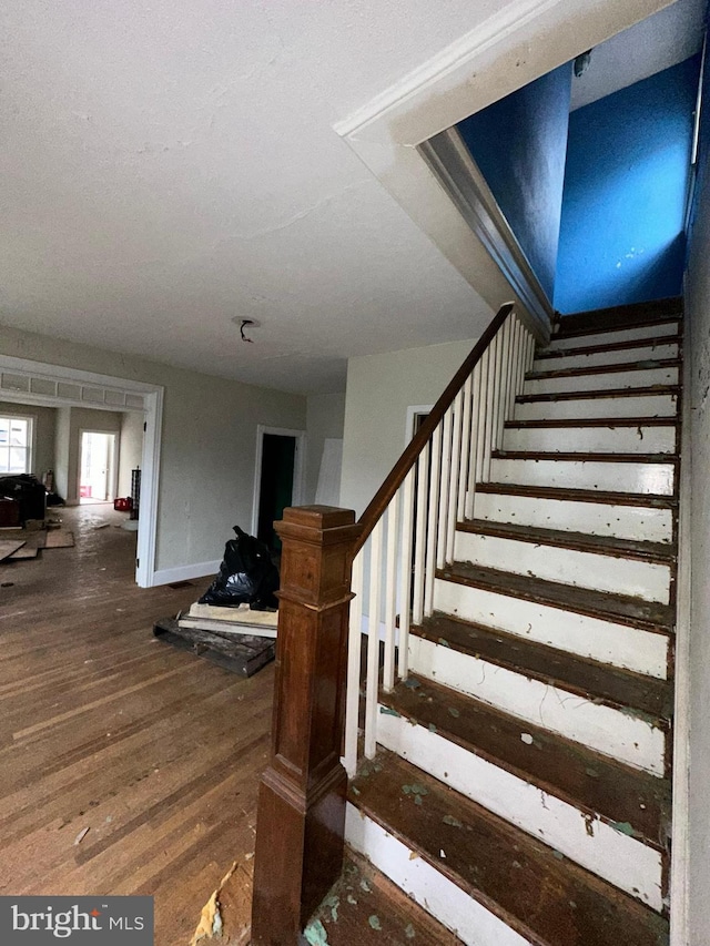 stairs with baseboards and wood finished floors