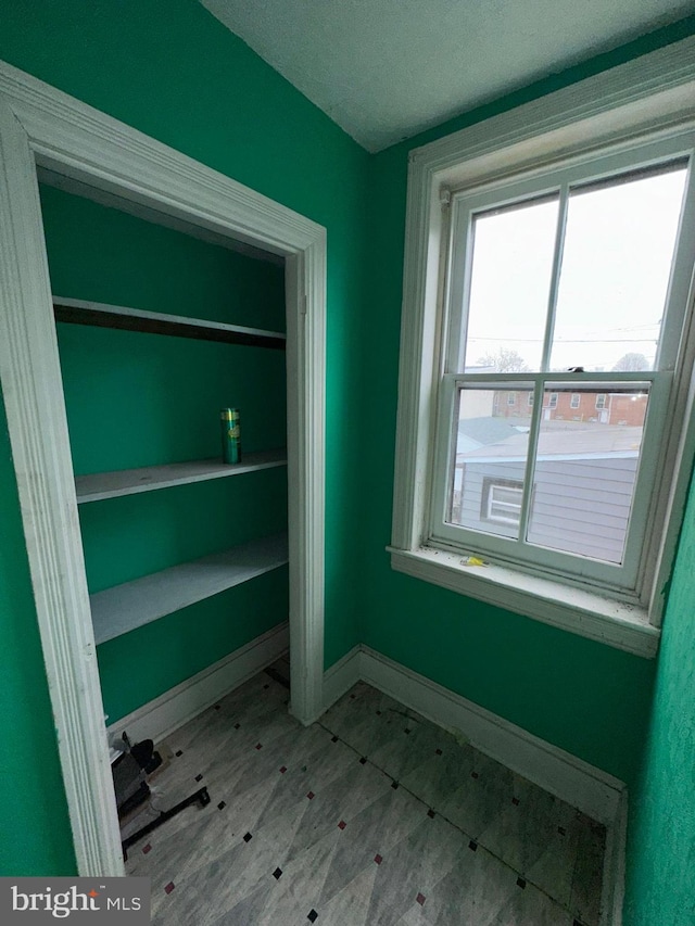interior space with a textured ceiling and baseboards