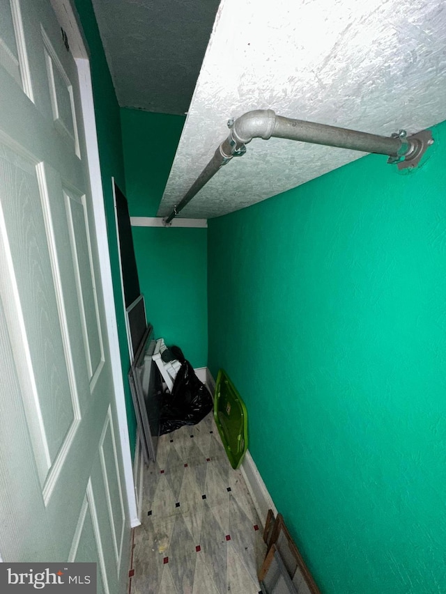 bedroom featuring a textured ceiling and baseboards