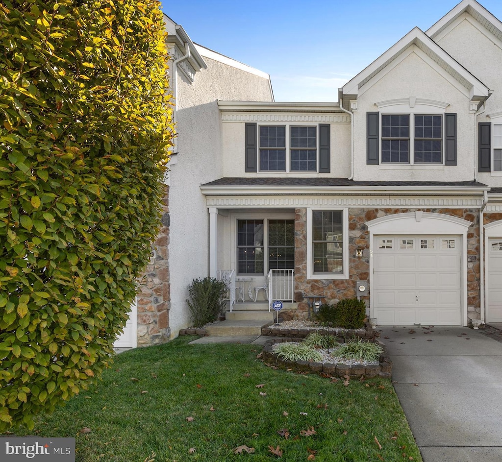 view of front of house featuring covered porch, a garage, and a front yard