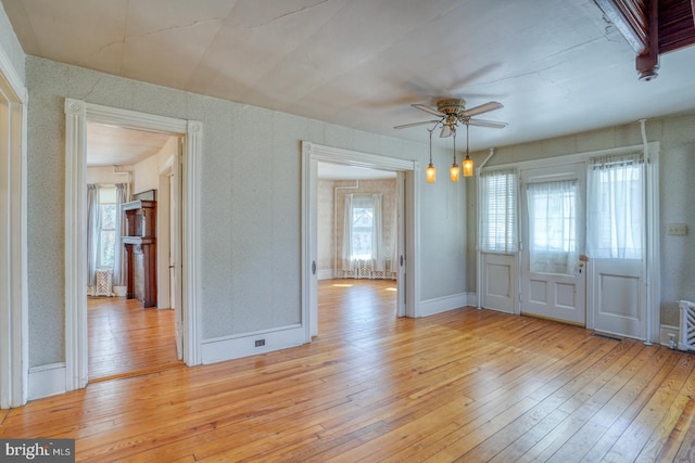 unfurnished dining area featuring ceiling fan and light hardwood / wood-style floors