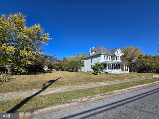 view of front of property with covered porch and a front yard