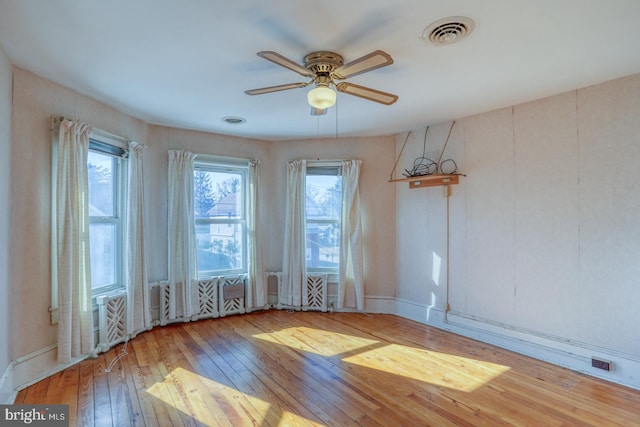 empty room with ceiling fan and light hardwood / wood-style floors