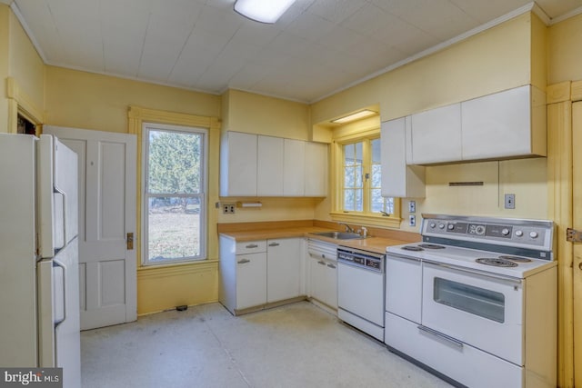 kitchen with white cabinetry, sink, white appliances, and ornamental molding