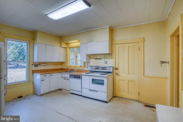 kitchen with white cabinetry, sink, and white appliances