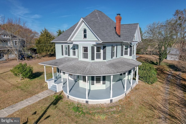 rear view of property with a yard and covered porch