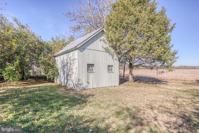 view of outdoor structure with a lawn and a rural view