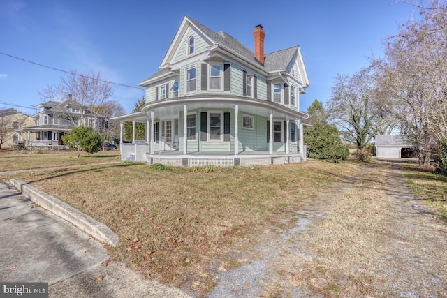 victorian-style house with a front yard and a porch