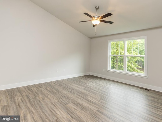 unfurnished room featuring lofted ceiling, light wood-type flooring, and ceiling fan