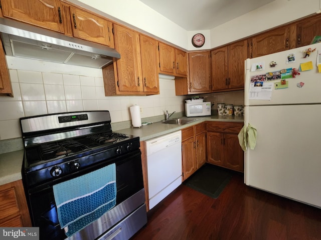 kitchen featuring decorative backsplash, dark hardwood / wood-style floors, exhaust hood, sink, and white appliances