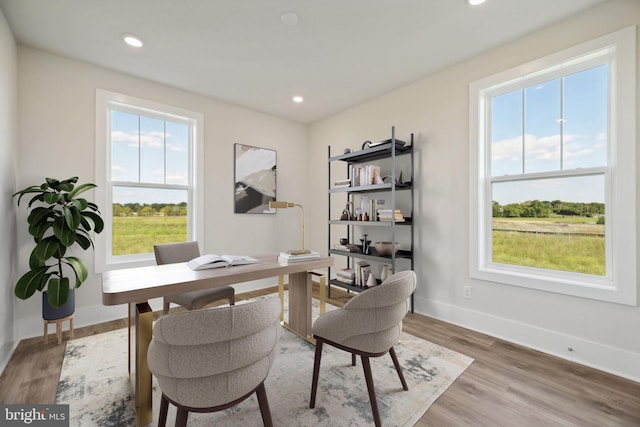 home office with hardwood / wood-style floors and a healthy amount of sunlight