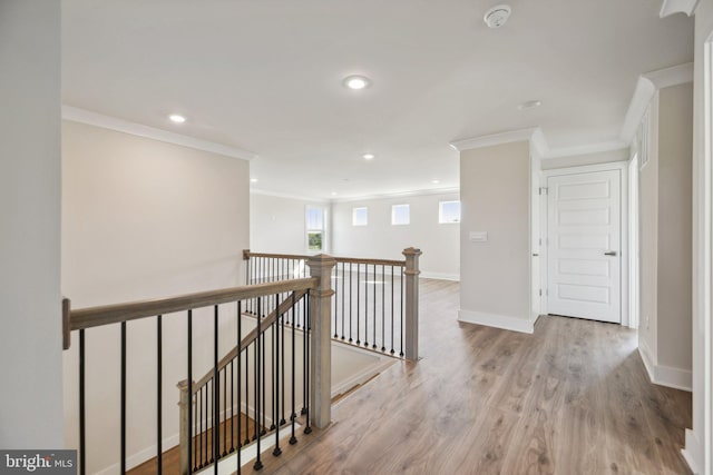 hall with ornamental molding and light hardwood / wood-style flooring