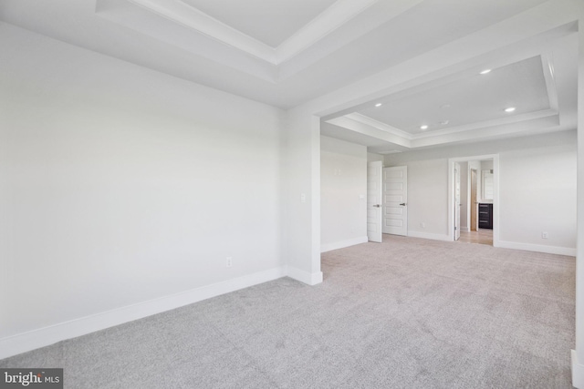 carpeted empty room featuring a raised ceiling