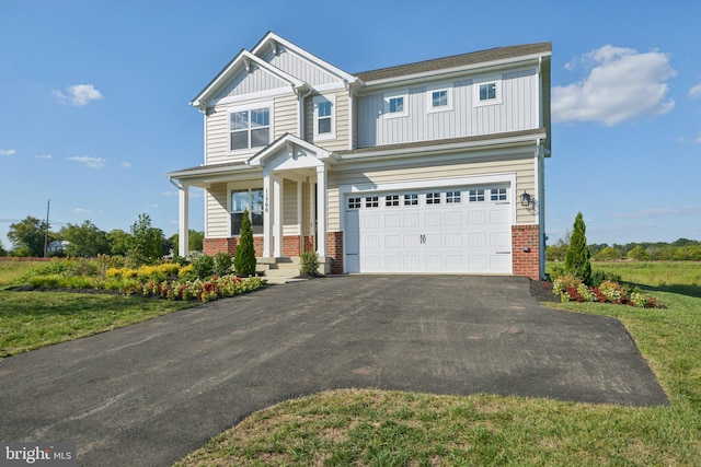 craftsman inspired home with a porch, a front lawn, and a garage