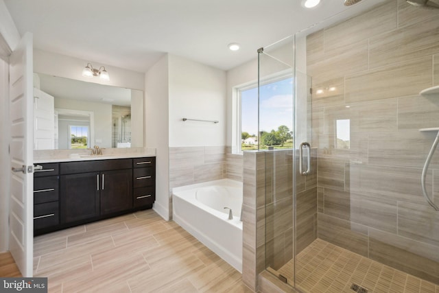 bathroom featuring vanity and independent shower and bath