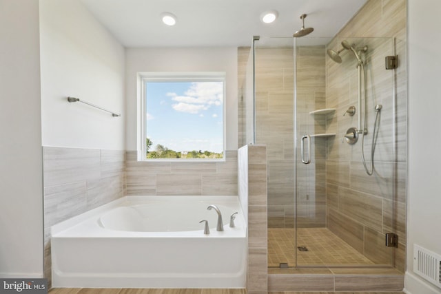 bathroom with wood-type flooring and separate shower and tub