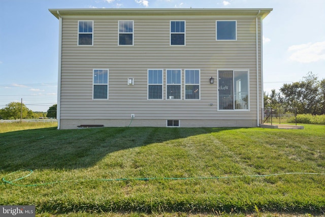 back of property featuring a lawn