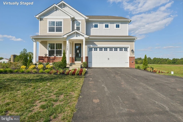 craftsman-style house featuring covered porch, a front yard, and a garage