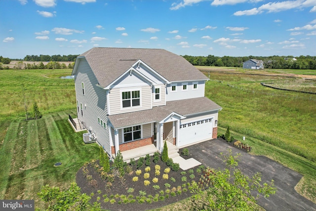 view of front facade featuring a front yard, ac unit, and a garage