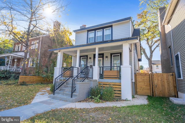 view of front of property featuring fence and a porch