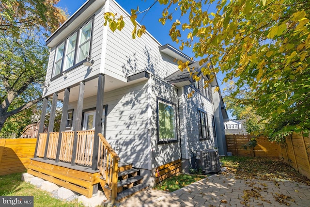 view of side of property featuring a fenced backyard and central air condition unit