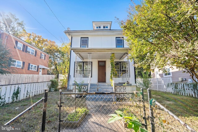 american foursquare style home with covered porch, a gate, and a fenced front yard