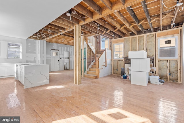 basement featuring sink and light hardwood / wood-style flooring