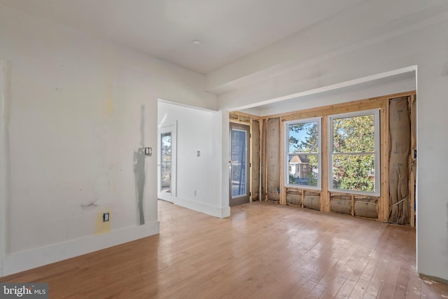 spare room featuring hardwood / wood-style flooring and baseboards