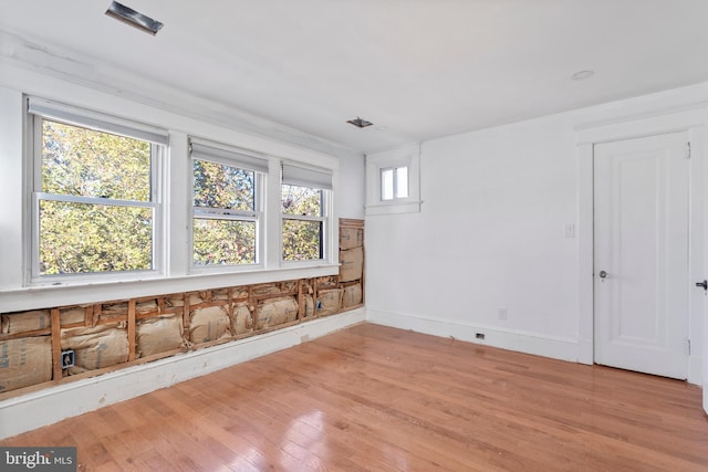 empty room with light wood finished floors and baseboards