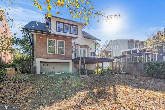 rear view of property with brick siding, fence, stairway, a garage, and a wooden deck