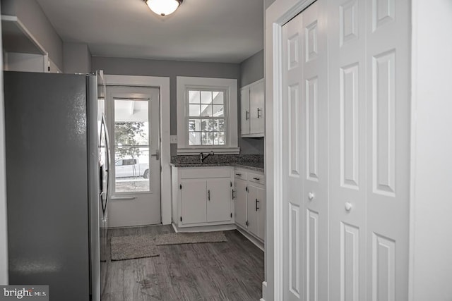 kitchen with stainless steel fridge, white cabinetry, dark wood-type flooring, and a healthy amount of sunlight