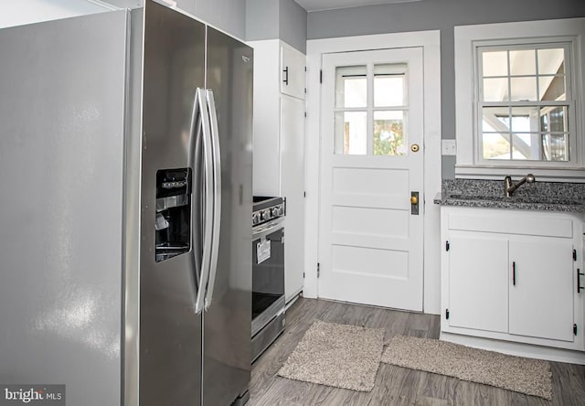 kitchen featuring dark wood-type flooring, white cabinets, and stainless steel appliances