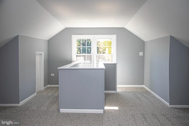 bonus room with light carpet and lofted ceiling