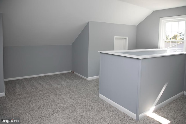 bonus room with light carpet and lofted ceiling