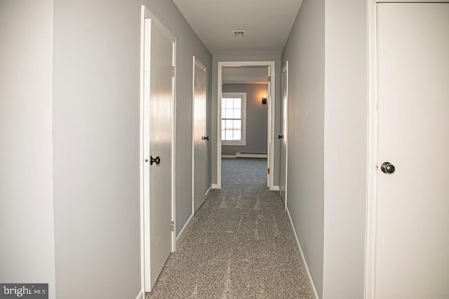 corridor featuring baseboard heating and carpet