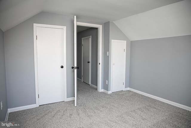 additional living space featuring vaulted ceiling and light colored carpet