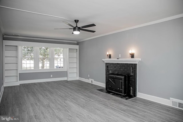 unfurnished living room featuring a brick fireplace, ornamental molding, ceiling fan, and dark hardwood / wood-style flooring