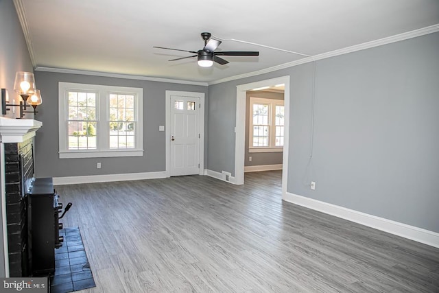 unfurnished living room featuring ceiling fan, ornamental molding, dark hardwood / wood-style flooring, and a brick fireplace