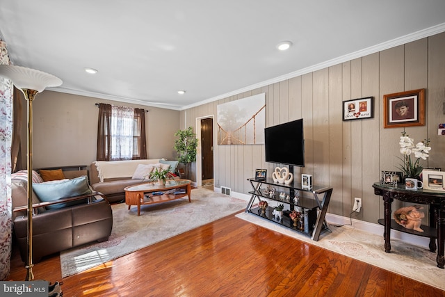 living room with crown molding and light wood-type flooring