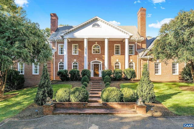 neoclassical / greek revival house featuring a front yard