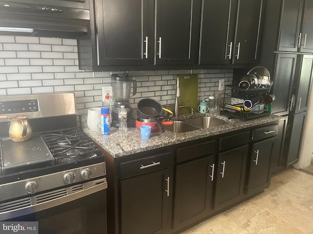 kitchen with stone counters, sink, decorative backsplash, stainless steel gas range, and exhaust hood