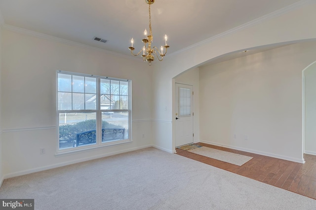 empty room with crown molding, light carpet, and a notable chandelier