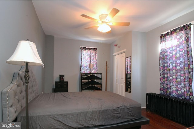 bedroom featuring radiator heating unit, dark hardwood / wood-style floors, and ceiling fan