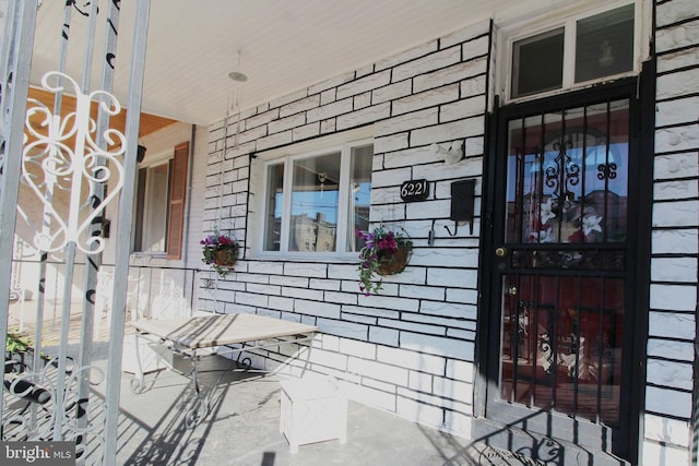 view of exterior entry featuring covered porch