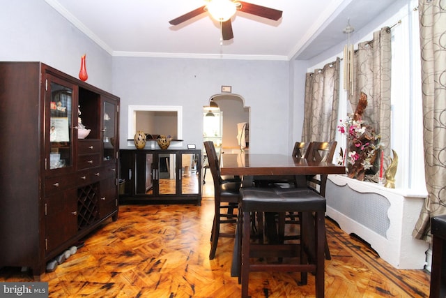 dining area featuring crown molding, dark parquet floors, and ceiling fan