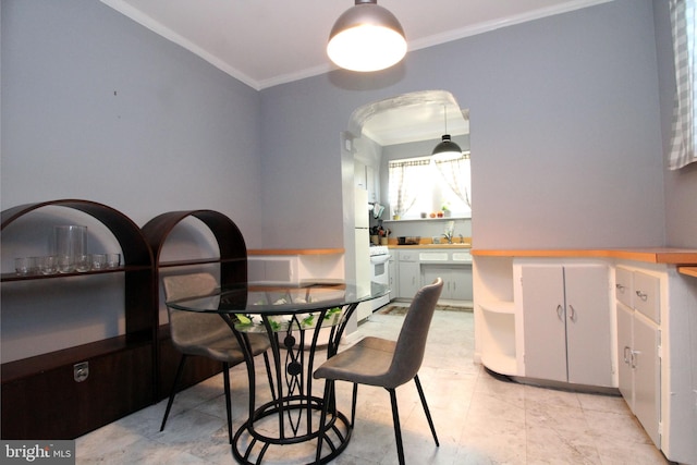 dining room with ornamental molding and sink