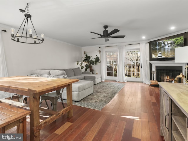 living room with hardwood / wood-style flooring, ceiling fan with notable chandelier, and ornamental molding