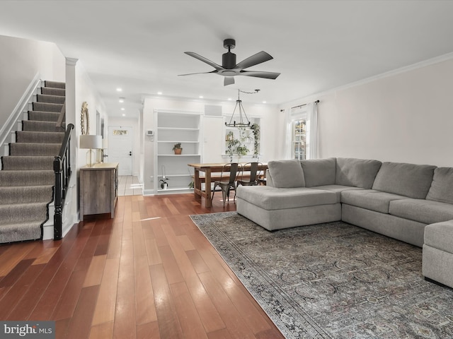 living room featuring wood-type flooring, ornamental molding, and ceiling fan