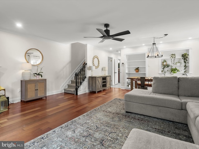 living room featuring ornamental molding, dark wood-type flooring, built in features, and ceiling fan